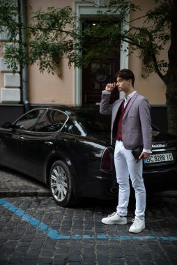 young man in suit talking on phone in office
