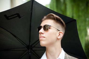 Şehirde şemsiyeli genç bir adam 