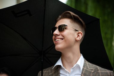 Şehirde şemsiyeli genç bir adam 