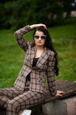 Güneş gözlüklü, dışarıda poz veren güzel bir kadın.