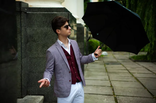 young man with umbrella in the city