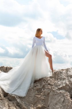 Plajda poz veren beyaz elbiseli güzel gelin. 