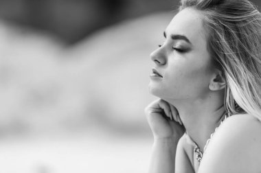 Sahilde poz veren güzel bir genç kadının portresi. 