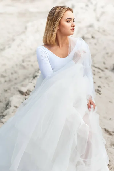白いドレスを着た美しい花嫁がビーチでポーズをとって — ストック写真