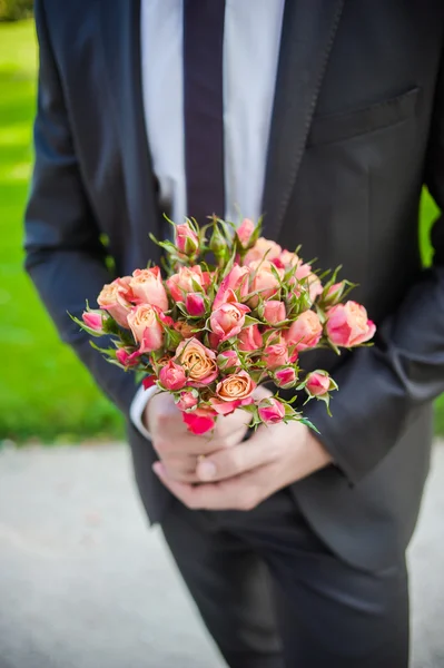 The groom in a suit or Young girl-bride or bridesmaid is holding a wedding bouquet — Stock Photo, Image