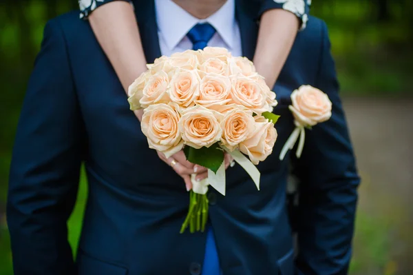 スーツや若い女の子の花嫁、花嫁介添人の新郎が結婚式の花束を保持しています。 — ストック写真