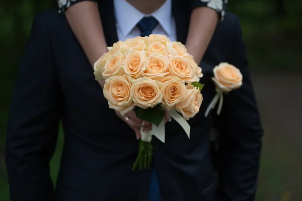 スーツや若い女の子の花嫁、花嫁介添人の新郎が結婚式の花束を保持しています。 — ストック写真