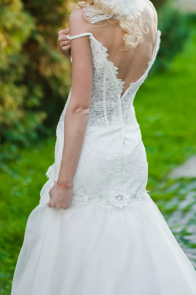 Красивая невеста в свадебном платье готовится к церемонии в церкви. Прогулка возле старого замка — стоковое фото