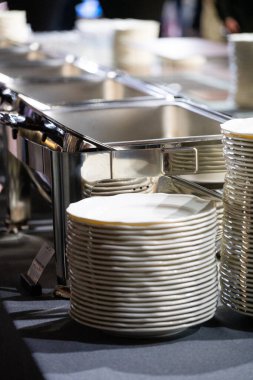 Temiz ve düzenli bir büfe ortamında hazırlanmış paslanmaz çelik mutfak ekipmanları servis istasyonları, tabaklar ve yiyecek ısıtıcılarıyla profesyonel bir yemek servisi. Konukseverlik ve restoran hizmeti için ideal.