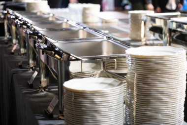 Temiz ve düzenli bir büfe ortamında hazırlanmış paslanmaz çelik mutfak ekipmanları servis istasyonları, tabaklar ve yiyecek ısıtıcılarıyla profesyonel bir yemek servisi. Konukseverlik ve restoran hizmeti için ideal.