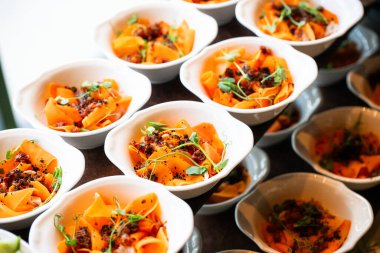 Profesyonel bir yemek servisinde salata, aperatif ve sıcak yemeklerin yer aldığı açık büfe masasında çeşitli taze yemekler sergileniyor.