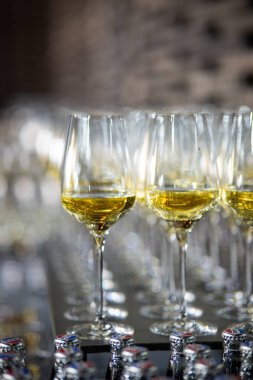 Lüks bir ortamda birçok şampanya kadehi. Tarz sahibi, koyu renkli bir fotoğraf. Yüksek sosyete resepsiyonu, yeni yıl kutlaması, düğün