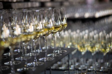 Lüks bir ortamda birçok şampanya kadehi. Tarz sahibi, koyu renkli bir fotoğraf. Yüksek sosyete resepsiyonu, yeni yıl kutlaması, düğün