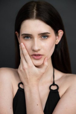 Siyah arka planda doğal makyajı olan güzel bir kadının portresi.