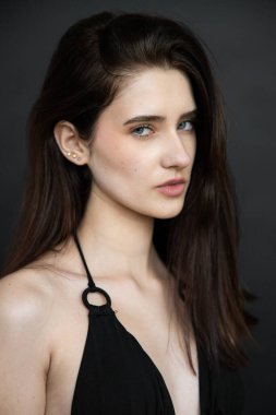 Siyah deri ceketli, güzel esmer bir mankenin portresi. Makyaj ve saç stili.