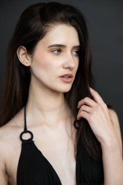 Koyu renk elbiseli, uzun saçlı güzel bir genç kız.