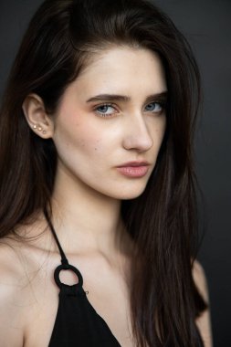 Koyu arkaplanda poz veren uzun siyah saçlı güzel bir kadın. güzellik ve moda konsepti.