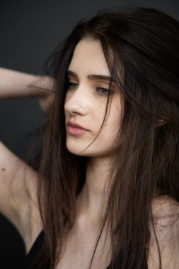 Stüdyoda poz veren uzun saçlı güzel bir kadın.
