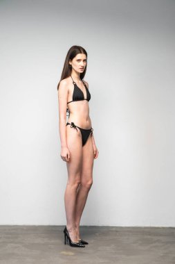 Stüdyoda siyah iç çamaşırlarıyla poz veren güzel bir kız.