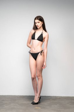 Beyaz arkaplanda siyah iç çamaşırlı, mükemmel bir kız, stüdyo fotoğrafı.