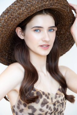 Beyaz arka planda şapkalı, kocaman bir gülümsemesi olan güzel bir kız. Mavi mayolu, büyük göğüslü kız..