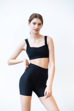 Beyaz arka planda ince vücutlu genç bir kadın.