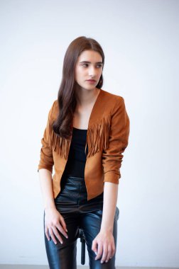 Gri arka planda uzun kahverengi saçlı moda kadını