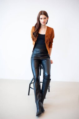 Beyaz arka planda deri ceketli güzel bir kızın portresi.