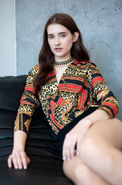 Stüdyoda poz veren şık elbiseli güzel esmer kadın.