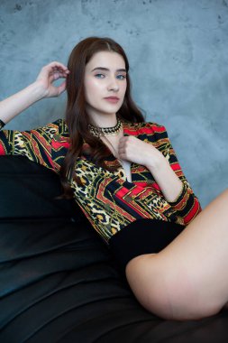 Yerde siyah elbiseli güzel bir esmerin moda portresi. Stüdyoda bir model.