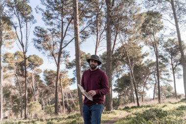 Çocuk doğada kitap okuyor.