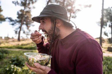 Çocuk doğada salata yiyor.
