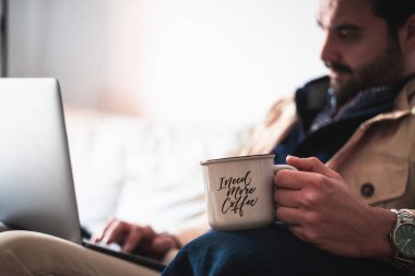 Adam evde çalışıyor, kahve içiyor.