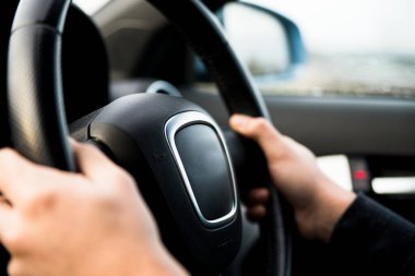 Tanımlanamayan kişi ellerini direksiyona koyar.