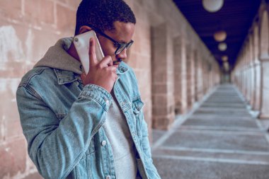 Siyah adam cep telefonuyla konuşuyor.