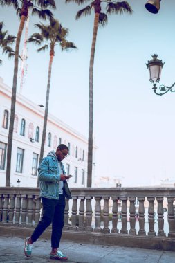 Siyah çocuk cep telefonu kullanıyor.