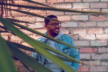Siyah çocuk tuğla duvarda poz veriyor