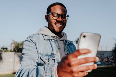 Siyah çocuk parkta video görüşmesi yapıyor.