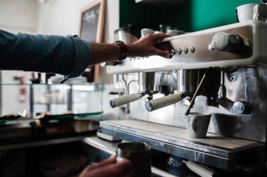 Kafeteryada kahve hazırlayan tanınmamış biri.