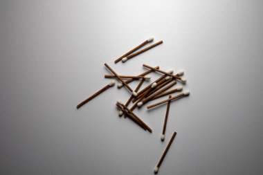 Bir demet kahverengi ve beyaz kibrit. Beyaz arka plan, birkaç kibrit kutusu. Tahta kibrit çöpleri. Stüdyo ışığı