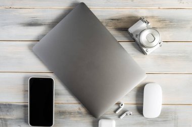 Items of modern technologies for working online and freelancing: laptop, mouse, smartphone, camera.