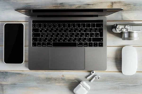 Items of modern technologies for working online and freelancing: laptop, mouse, smartphone, camera.