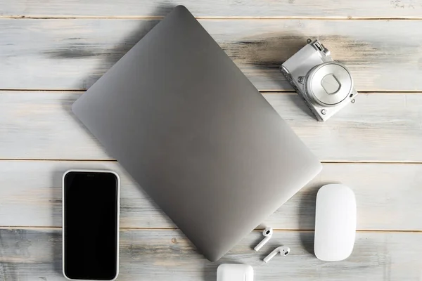 Items of modern technologies for working online and freelancing: laptop, mouse, smartphone, camera.