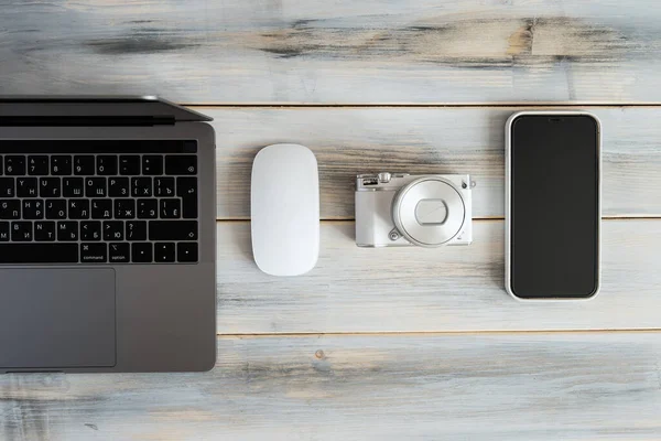 Items of modern technologies for working online and freelancing: laptop, mouse, smartphone, camera.