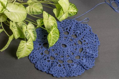 Yünden örülmüş, el ve dekoratif bitkilerle örülmüş bir parça örgü.