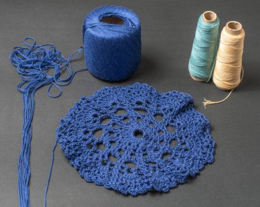 Yünden yapılmış bir örgü parçası ve elle örülmüş, farklı renklerde yün tomurcuklar.