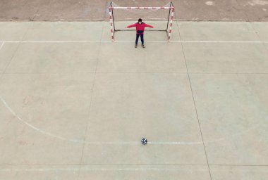 Ağı ve kalecisi erkek olan yıldızlı siyah topu olan 7 'ye 7' lik bir futbol kalesinin en üst görüntüsü..