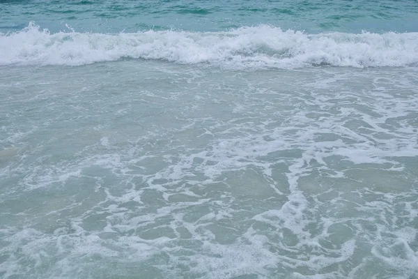 Крупный план волны синего моря на пляже — стоковое фото