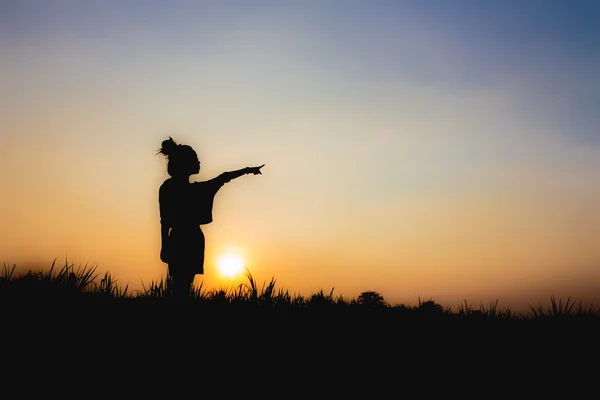 在夕阳下，站立的姿势，附近朦胧气氛里女人的剪影 — 图库照片