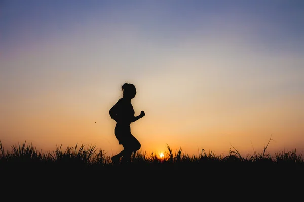 Silhouette di donna al tramonto, correre postura, vicino atmosfera fioca — Foto Stock